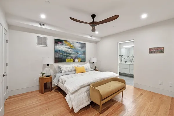 a bedroom with a large bed and a wooden floor