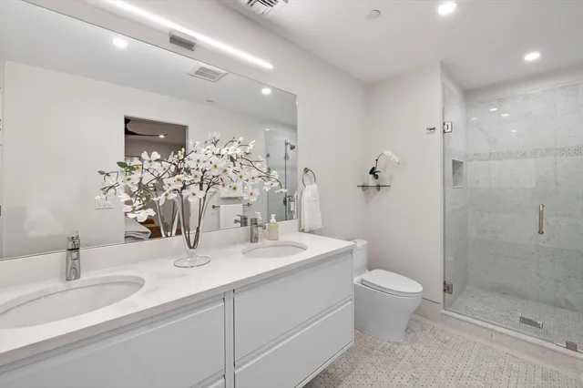 a bathroom with a sink a toilet and shower