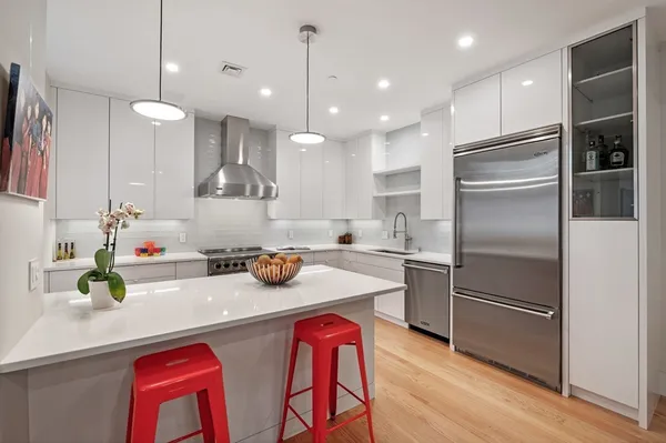 a kitchen with kitchen island wooden floor cabinets and appliances