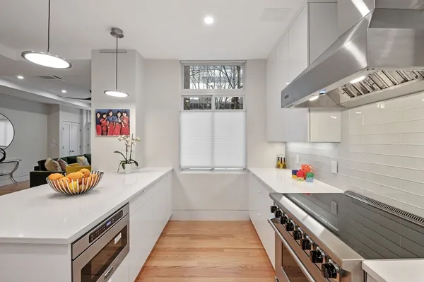 a kitchen that has a lot of cabinets and wooden floor