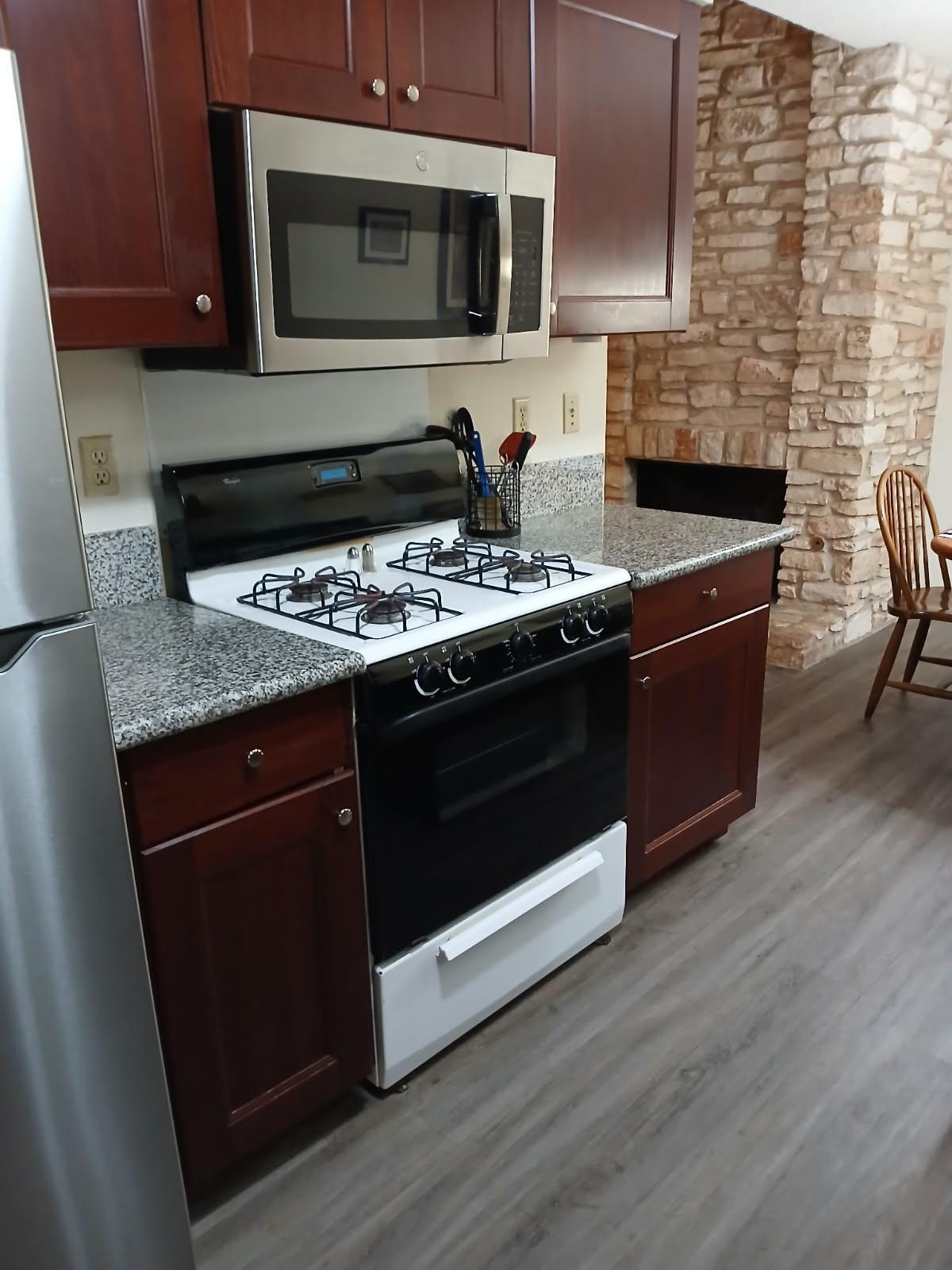 12905 Pegasus Street Austin, TX 78727 - Photo 12 of 32 a kitchen with stainless steel appliances granite countertop a stove and a microwave