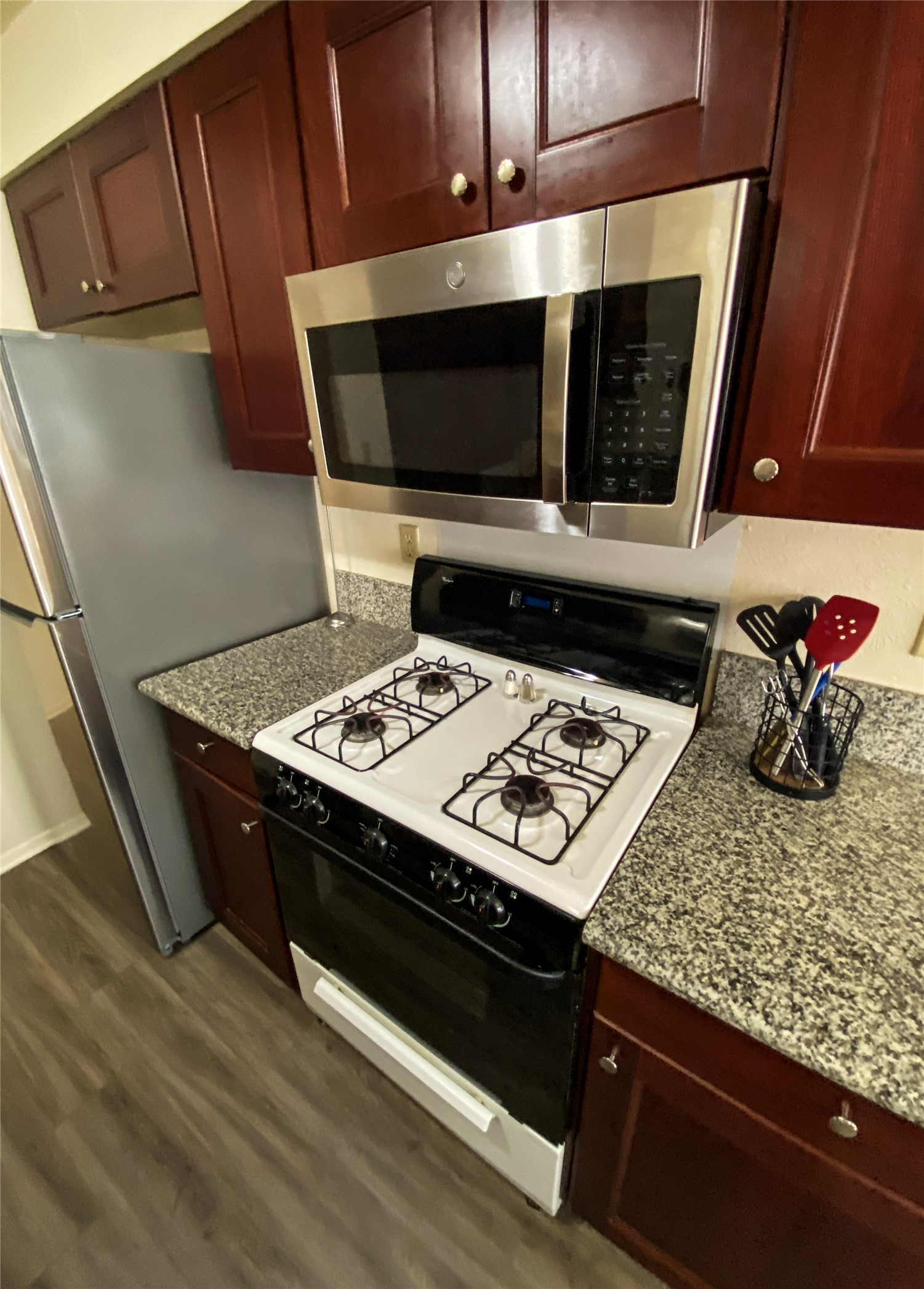 12905 Pegasus Street Austin, TX 78727 - Photo 13 of 32 a wooden floor and a stove top oven sitting inside of a kitchen