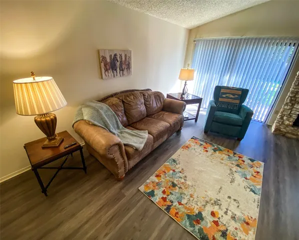 a living room with a couch and a dresser with wooden floor
