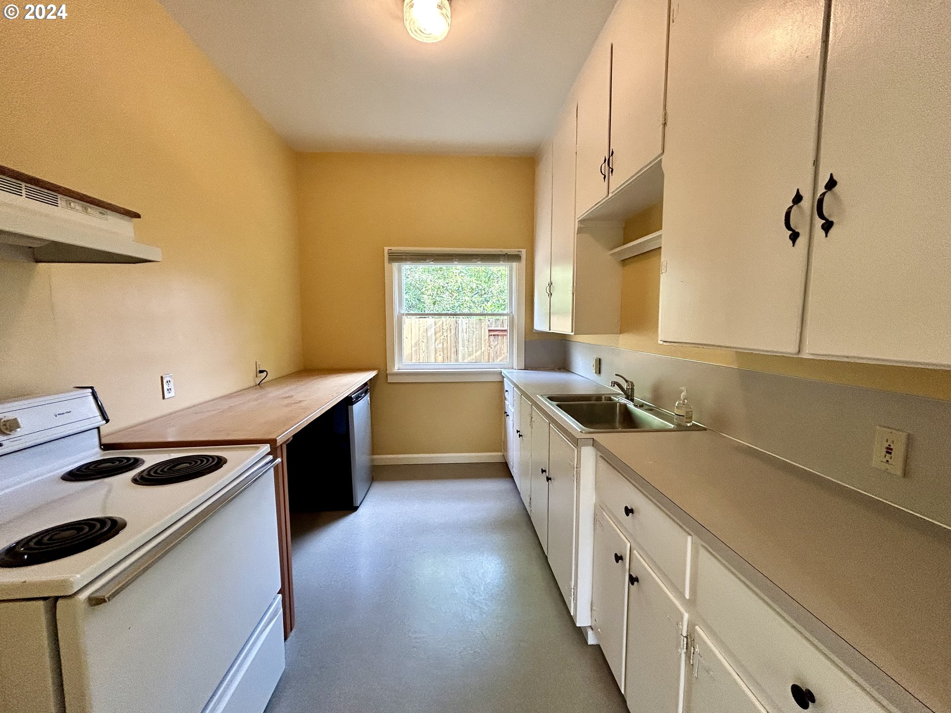 329 5th Street Springfield, OR 97477 - Photo 14 of 35 a kitchen with a sink stove top oven and cabinets