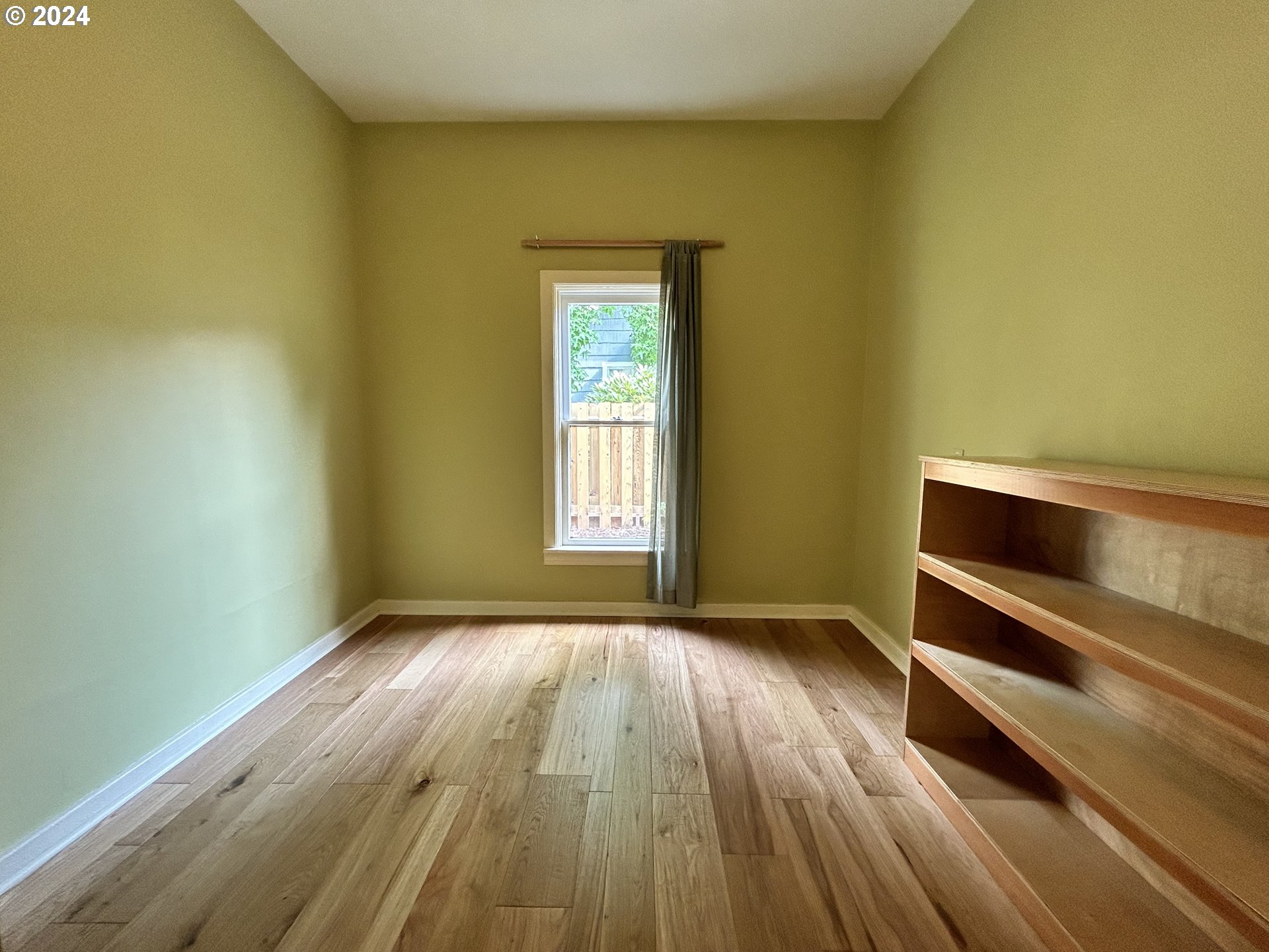 329 5th Street Springfield, OR 97477 - Photo 18 of 35 a view of an empty room with wooden floor and a window