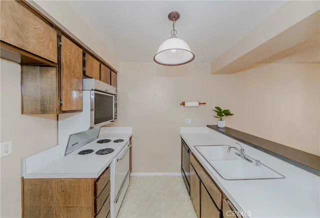 a kitchen with stainless steel appliances a stove a sink and a refrigerator