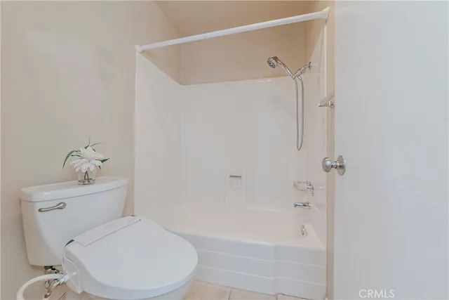 a white toilet sitting next to a bath tub