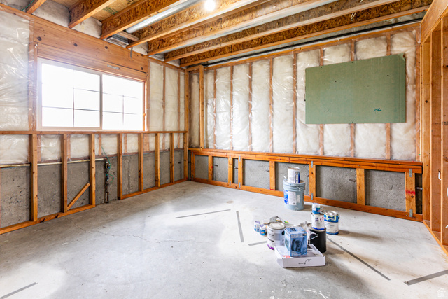 4239 West 5325th Street South Roy, UT 84067 - Photo 17 of 26 Unfinished basement space featuring visible wood framing, concrete foundation walls, and a large multi-pane window