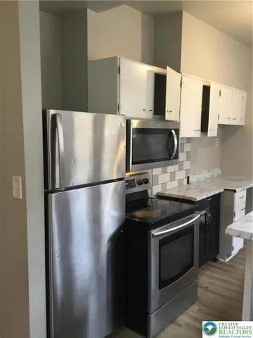 a kitchen with stainless steel appliances a refrigerator stove and microwave
