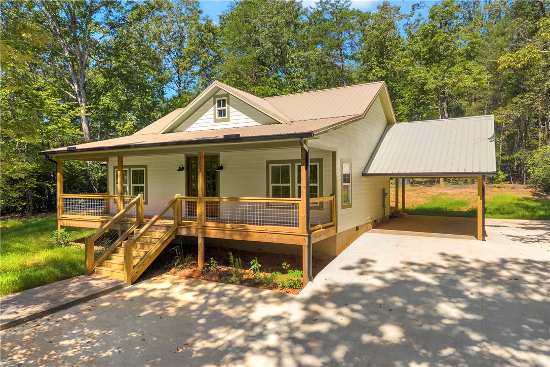 659 White Oak Farms Road Tamassee, SC 29686 - Photo 2 of 50 An inviting covered front porch and adjacent carport welcome you to this woodland retreat.
