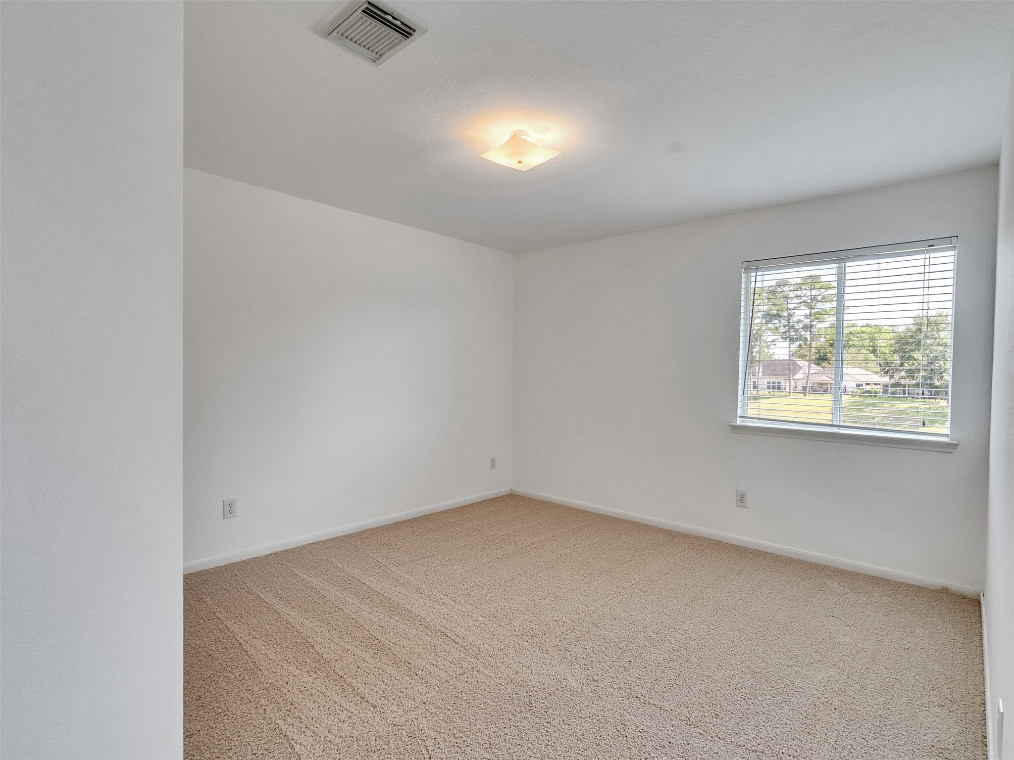 3307 Manor Tree Lane Houston, TX 77068 - Photo 22 of 44 Bright, spacious room with neutral carpet, white walls, a ceiling light, and a large window providing natural light and a pleasant view.