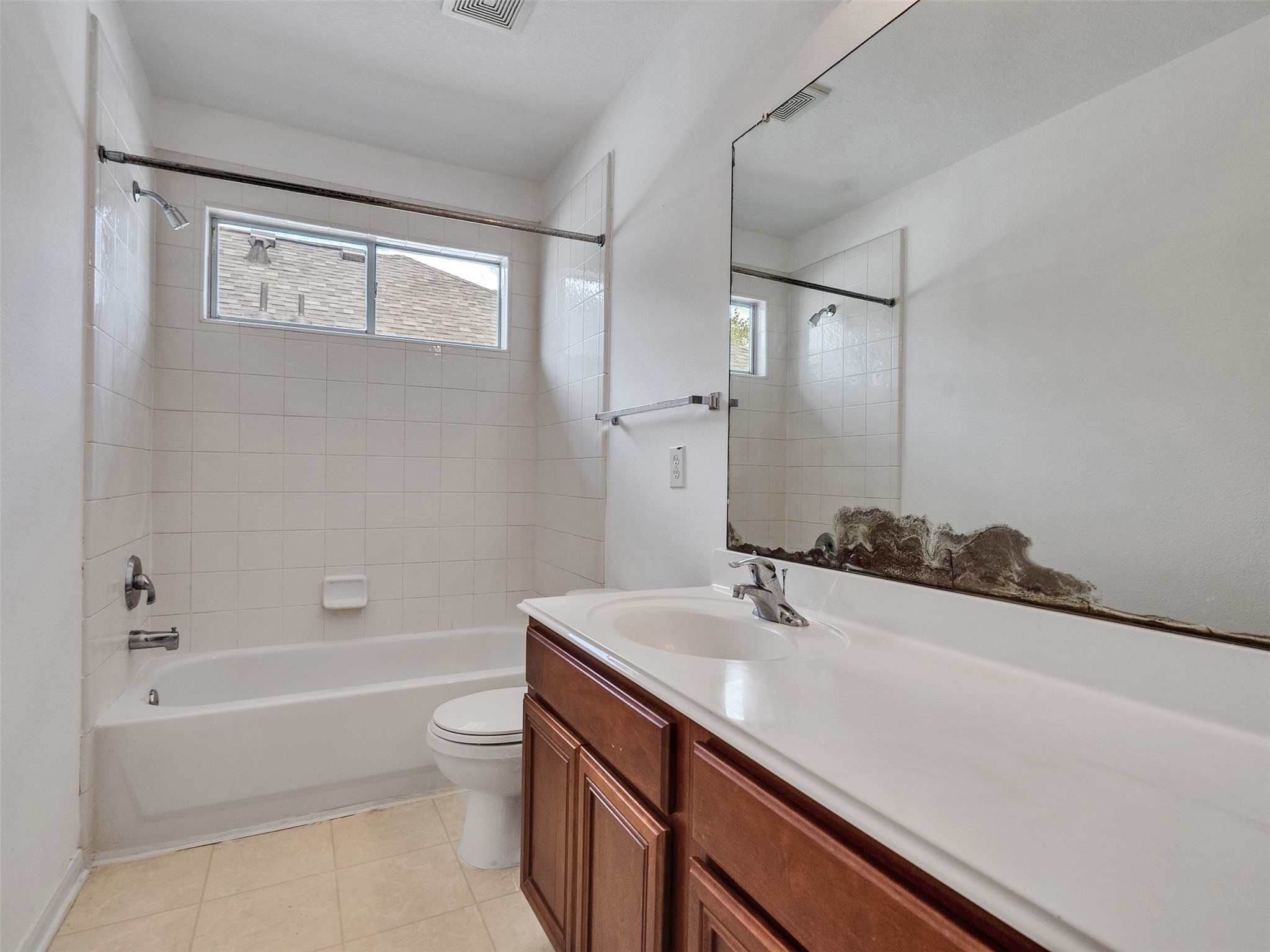 3307 Manor Tree Lane Houston, TX 77068 - Photo 23 of 44 This up stairs bathroom features a clean, simple design with a bathtub and shower combo, a large mirror, and a wooden vanity with a single sink. Natural light enters through a frosted window, creating a bright and inviting space.