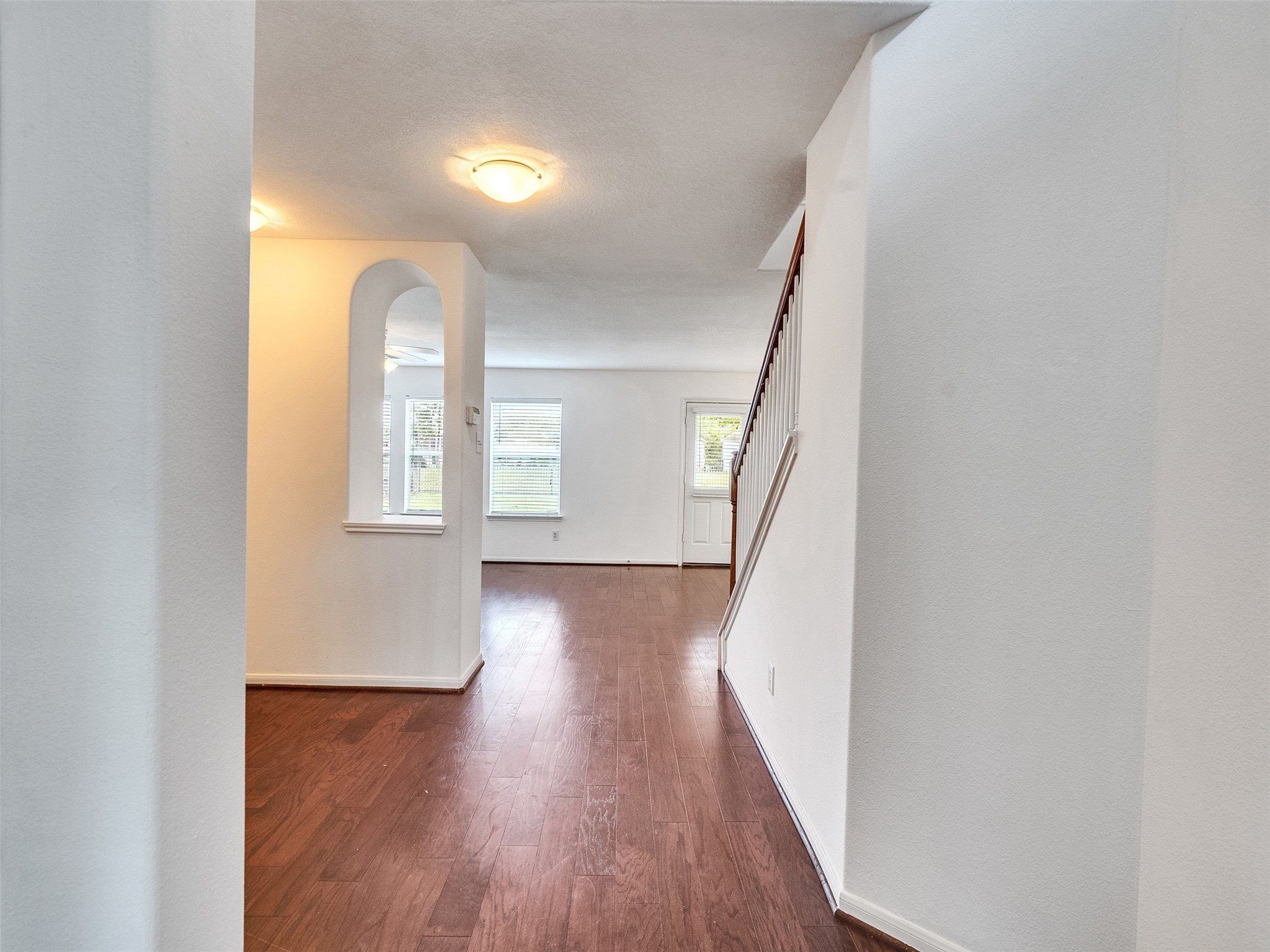 3307 Manor Tree Lane Houston, TX 77068 - Photo 3 of 44 This photo showcases a bright, open entryway with hardwood flooring, leading to a living area with large windows and a staircase. The space feels inviting and well-lit.