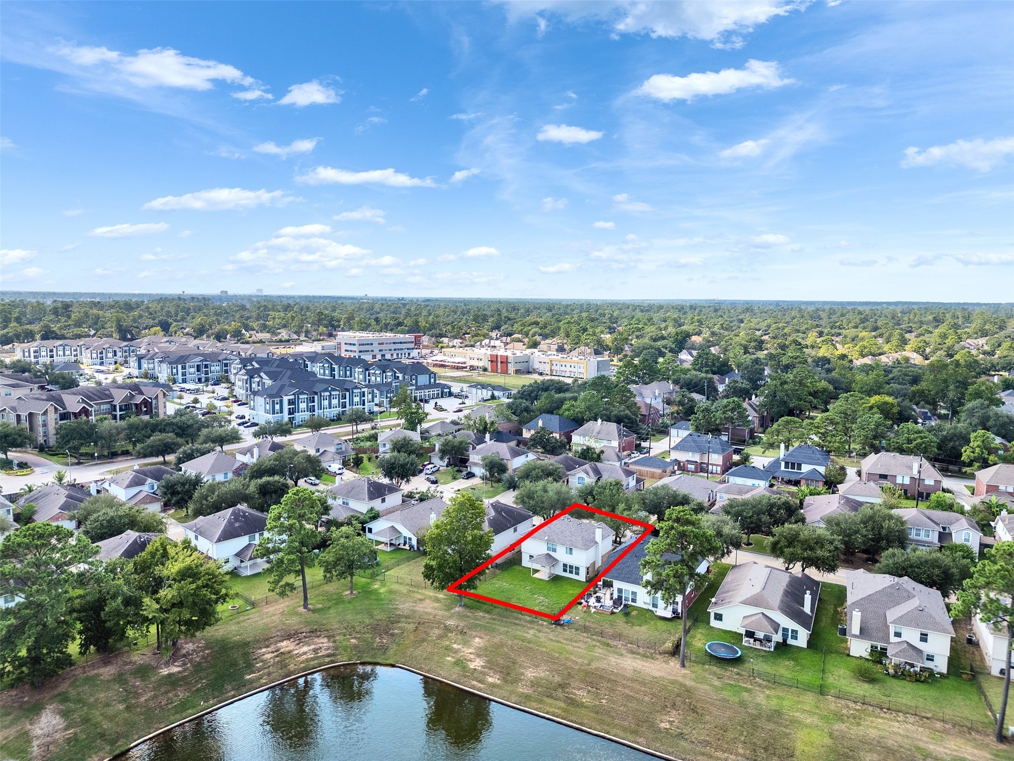 3307 Manor Tree Lane Houston, TX 77068 - Photo 35 of 44 This aerial photo showcases a suburban neighborhood with a highlighted two-story home near a pond. The area features mature trees, well-maintained lawns, and nearby amenities, offering a peaceful and convenient living environment.