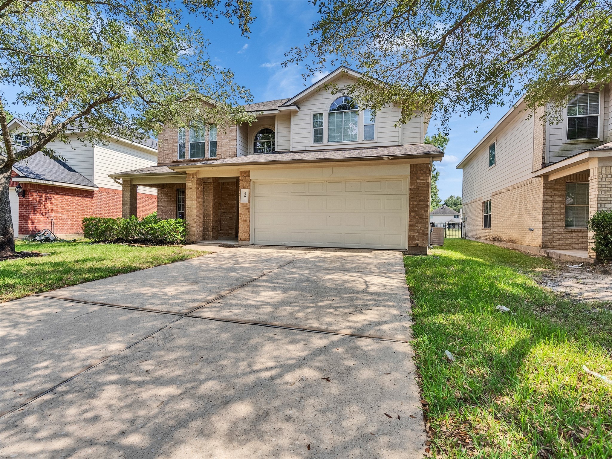 3307 Manor Tree Lane Houston, TX 77068 - Photo 41 of 44 This charming two-story home features a brick facade with a double garage, a spacious driveway, and a well-maintained lawn. It's nestled in a quiet neighborhood with mature trees providing shade.