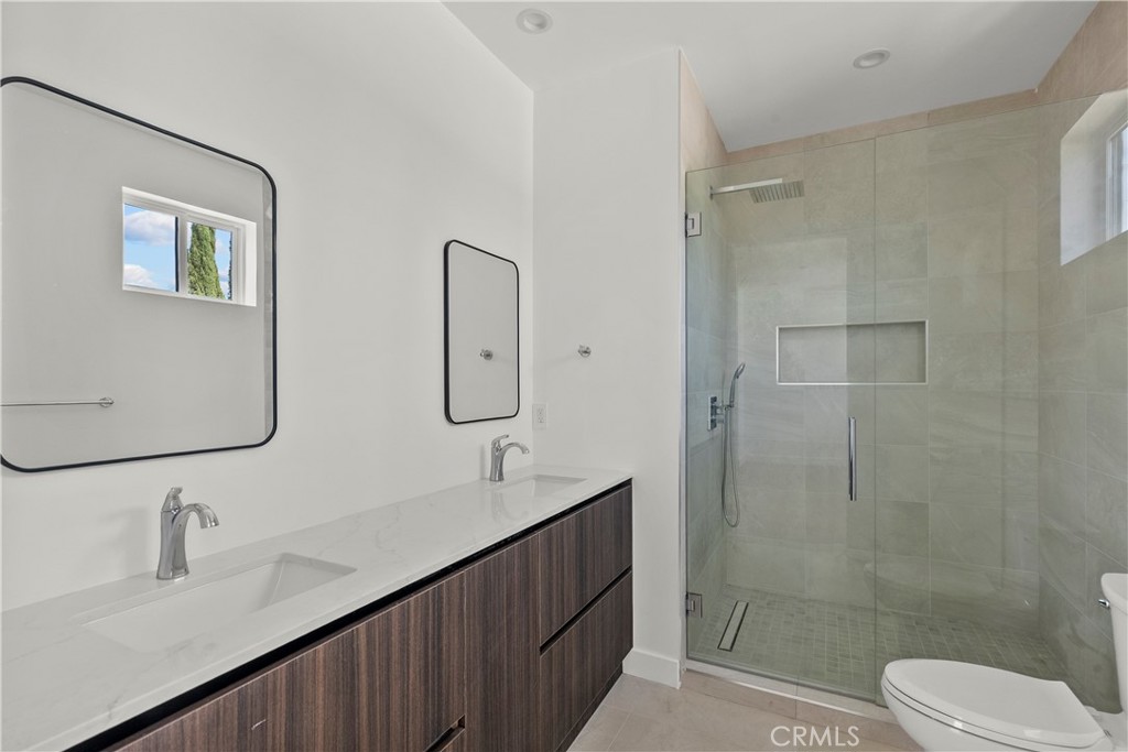 13942 Vanowen Street Van Nuys, CA 91405 - Photo 19 of 21 a bathroom with double vanity sink a mirror and a shower