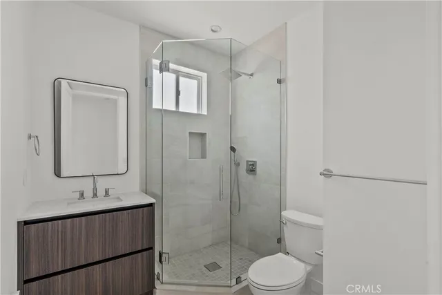 a bathroom with a granite countertop sink toilet a mirror a vanity and shower