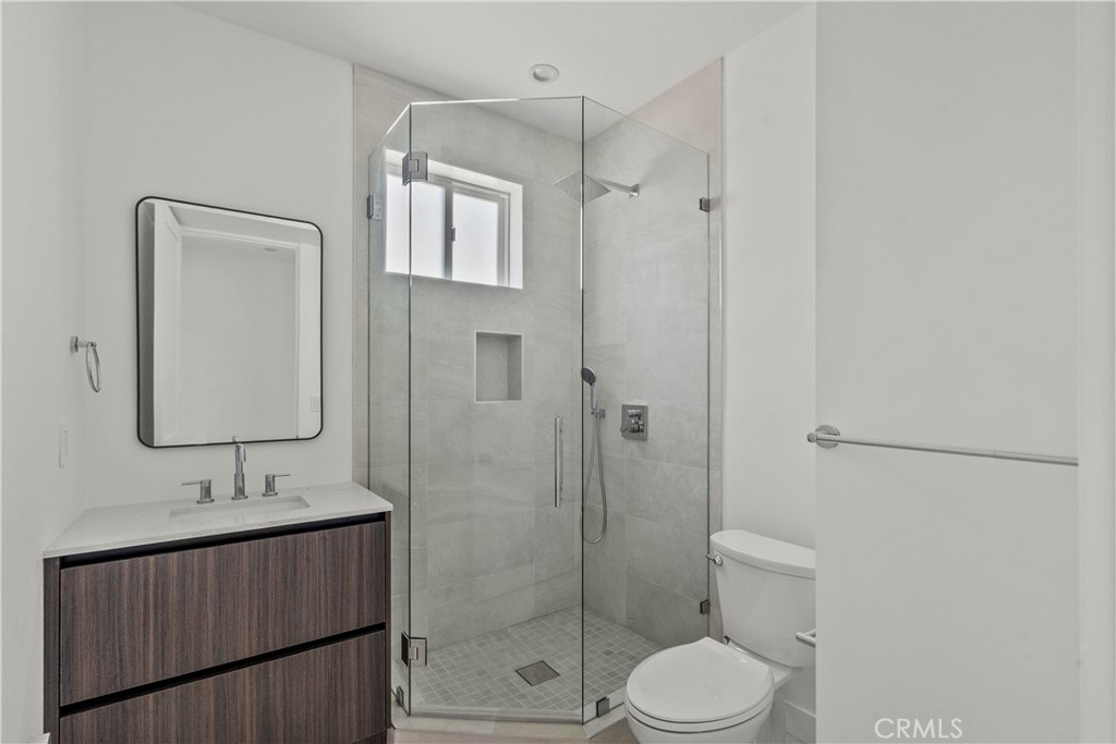 13942 Vanowen Street Van Nuys, CA 91405 - Photo 4 of 21 a bathroom with a granite countertop sink toilet a mirror a vanity and shower