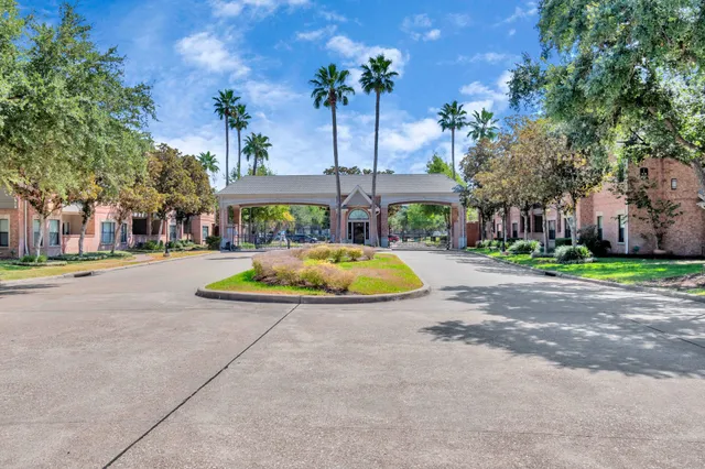 a front view of a house with a yard and fountain in middle