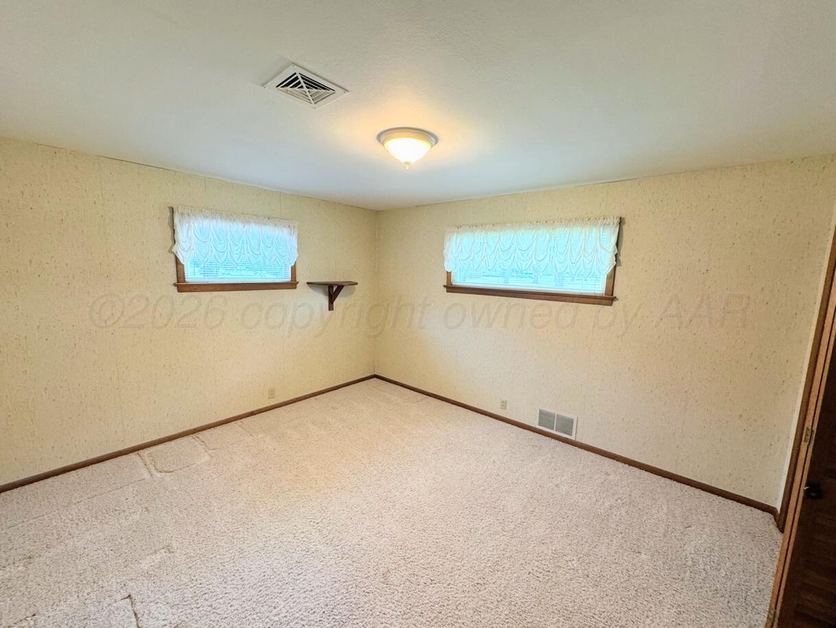1709 South Eton Street Perryton, TX 79070 - Photo 11 of 22 an empty room with a refrigerator