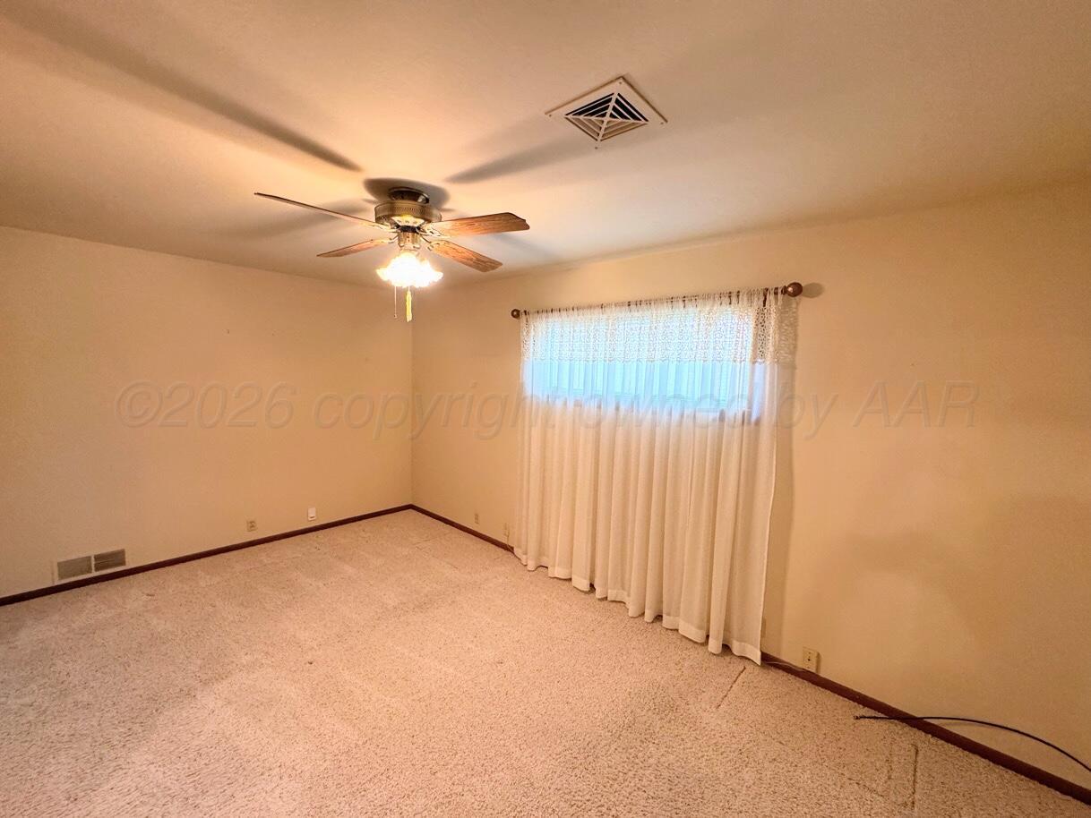1709 South Eton Street Perryton, TX 79070 - Photo 12 of 22 an empty room with windows and fan