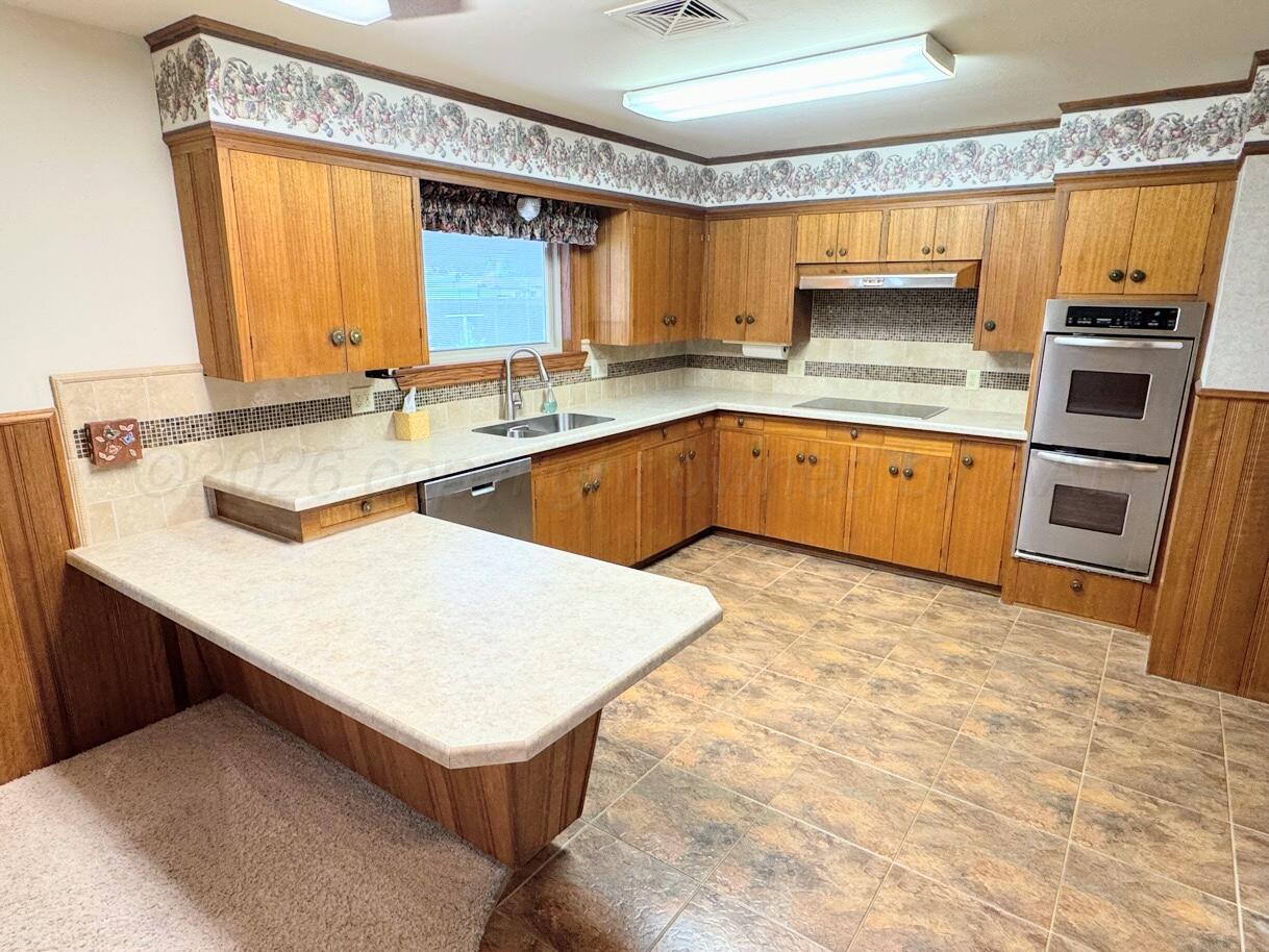 1709 South Eton Street Perryton, TX 79070 - Photo 4 of 22 a kitchen with stainless steel appliances granite countertop a sink stove and refrigerator