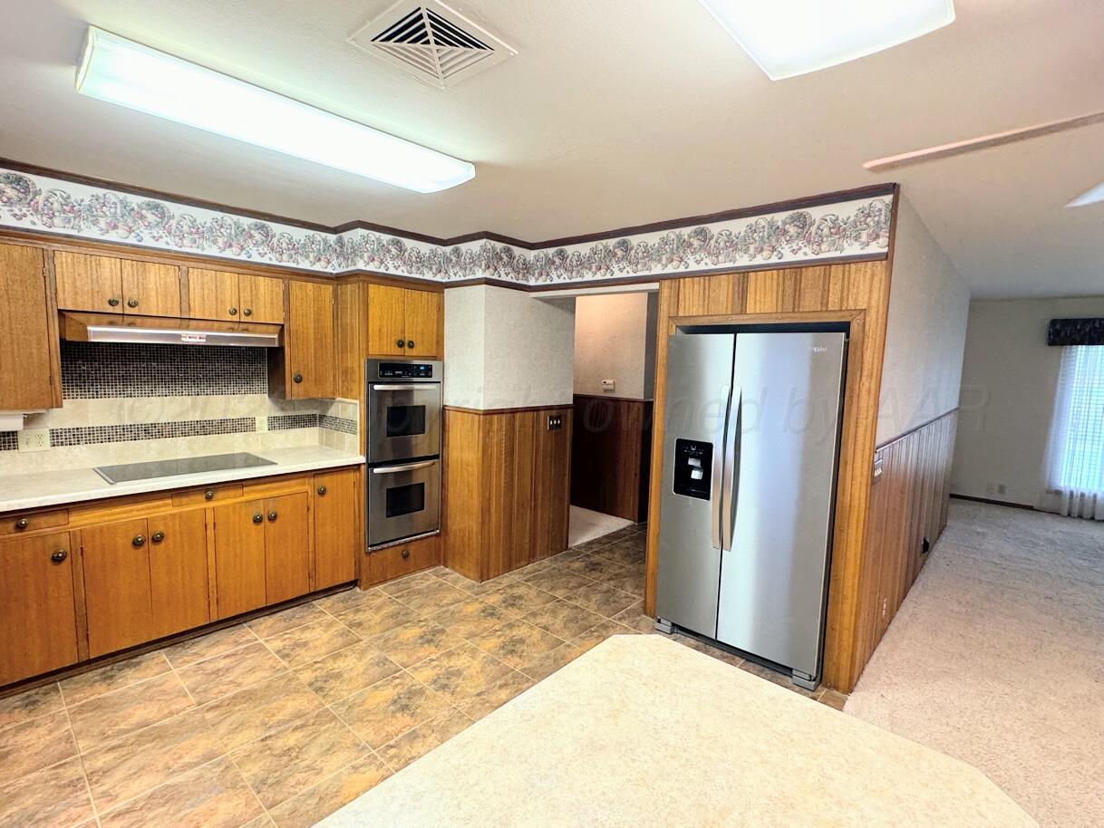 1709 South Eton Street Perryton, TX 79070 - Photo 5 of 22 a kitchen with stainless steel appliances granite countertop a refrigerator and a sink