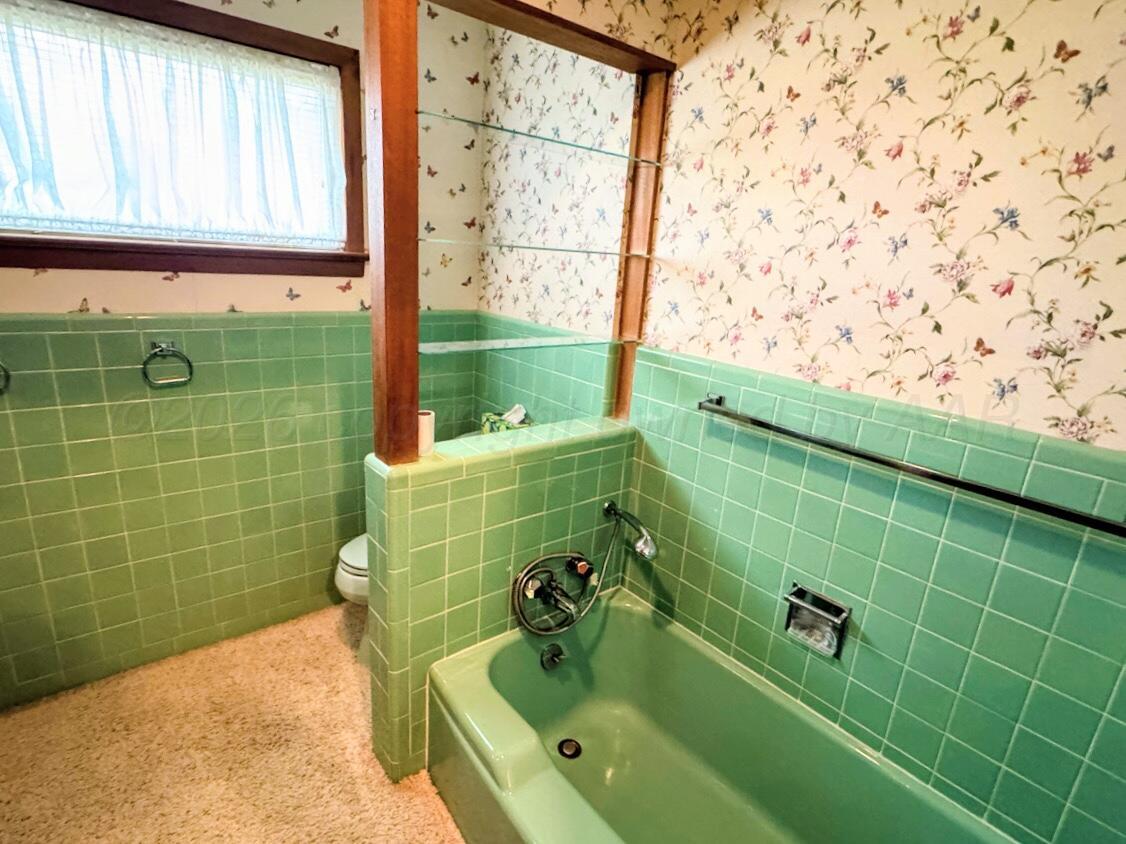 1709 South Eton Street Perryton, TX 79070 - Photo 9 of 22 a bathroom with a bathtub and a shower