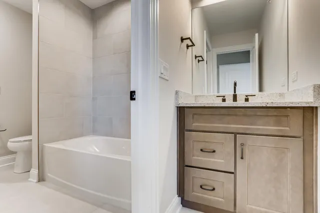 a bathroom with a bathtub sink vanity and toilet