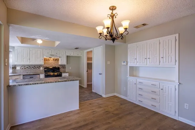 a kitchen with granite countertop a sink and cabinets