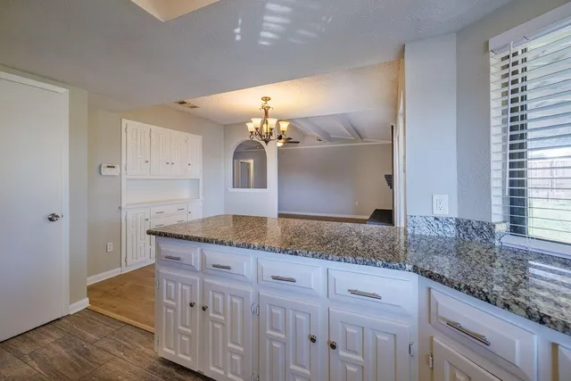 a kitchen with stainless steel appliances granite countertop a stove a refrigerator and a sink with wooden floors