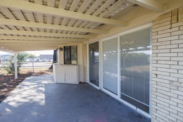 a view of an empty room with a fireplace and a window