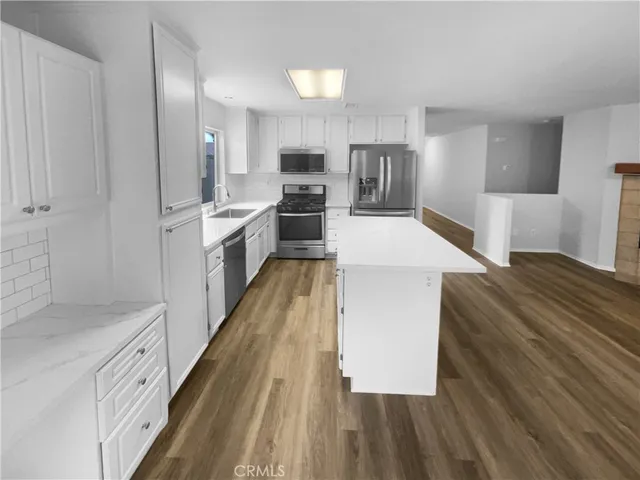 a large kitchen with a large counter top appliances and cabinets