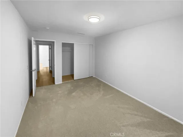an empty room with closet and wooden door