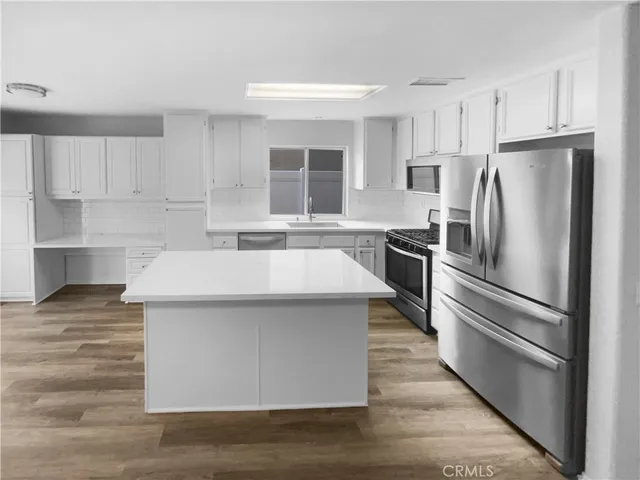 a kitchen with kitchen island a sink stainless steel appliances and cabinets