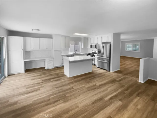 a kitchen with a refrigerator and a stove top oven