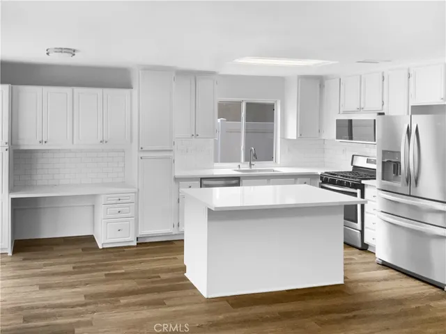 a kitchen with stainless steel appliances a stove top oven and refrigerator