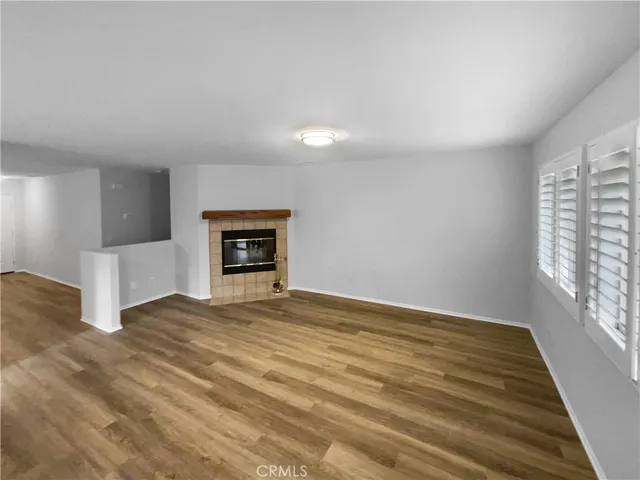 a view of empty room with wooden floor and fireplace