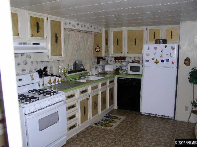 15075 Rhyolite Circle Reno, NV 89521 - Photo 2 of 9 a kitchen with stainless steel appliances a stove a sink and a refrigerator