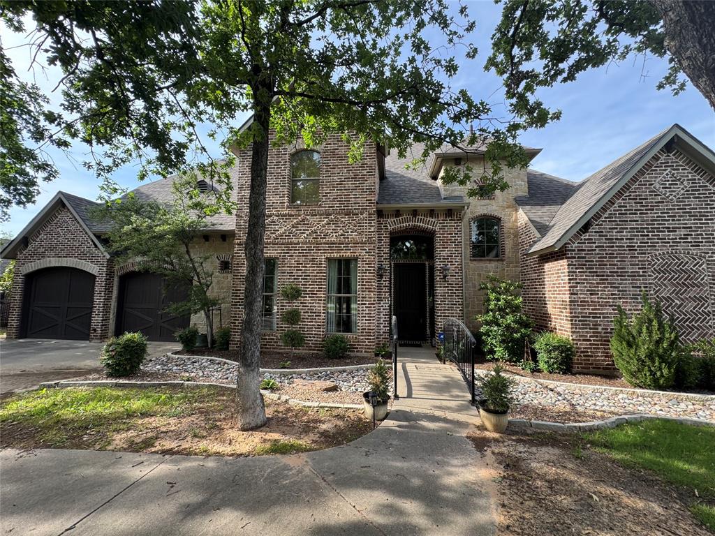 117 Woodland Drive Krugerville, TX 76227 - Photo 1 of 1 French country style house with brick siding, a shingled roof, driveway, and a garage