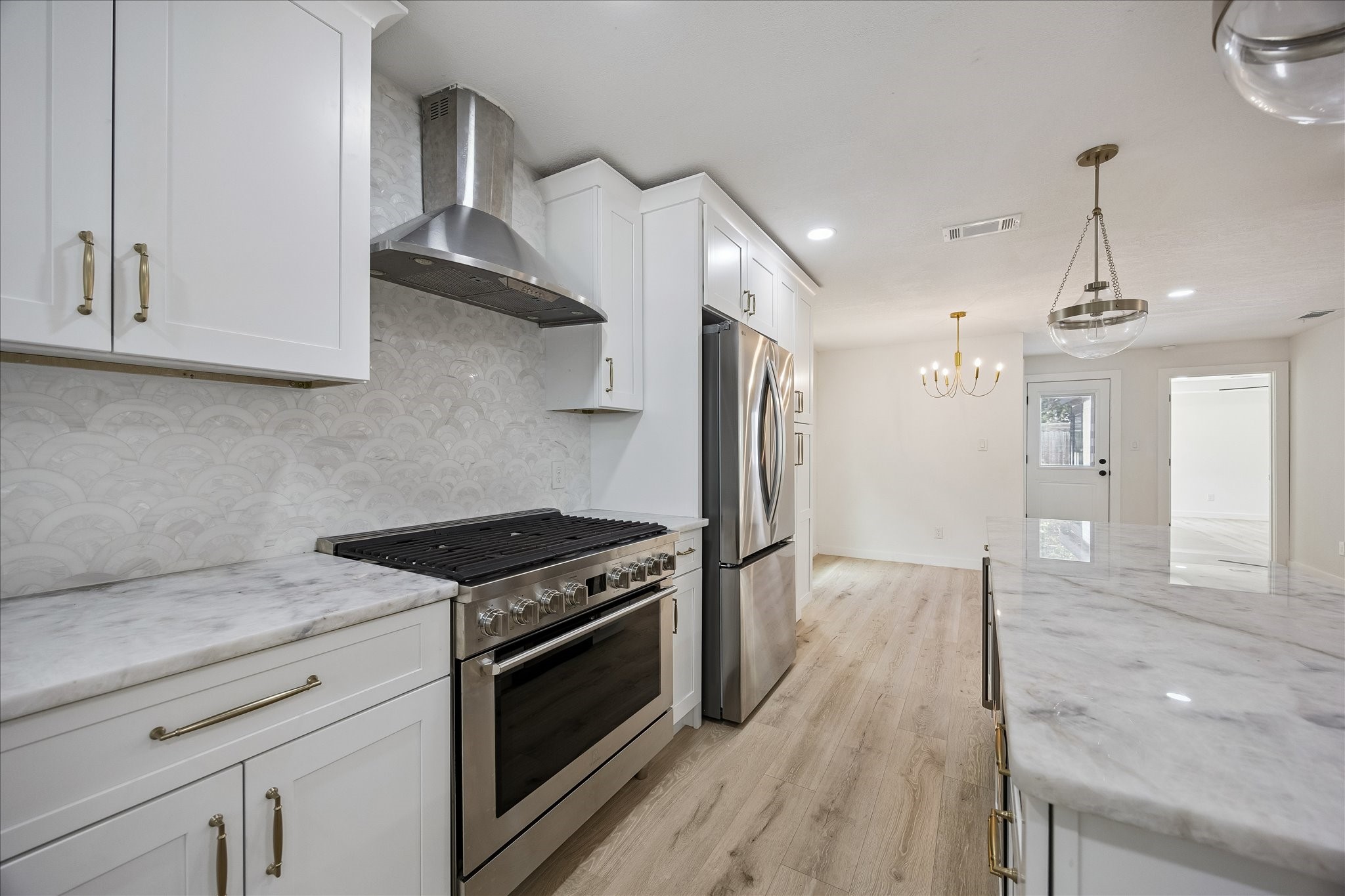 1630 Tabor Street Houston, TX 77009 - Photo 2 of 25 The kitchen is equipped with quartzite countertops, marble backsplash plus a full size refrigerator and a wine refrigerator.