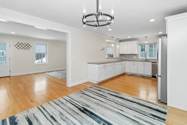 a view of a kitchen with kitchen island a sink wooden floor and appliances