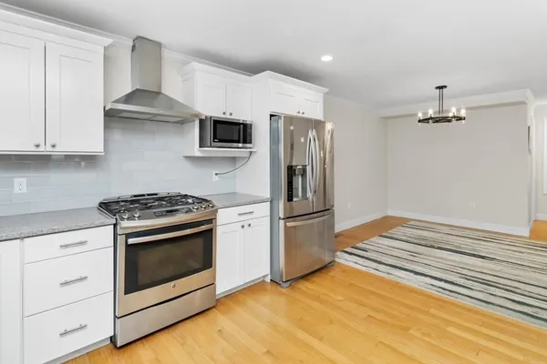 a kitchen with white cabinets and stainless steel appliances