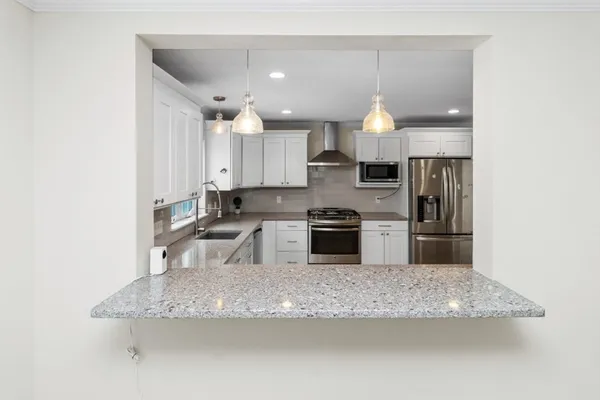 a kitchen with stainless steel appliances granite countertop a sink stove and refrigerator