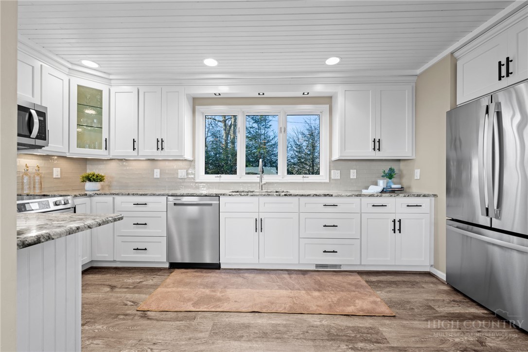 351 Windy Knob Trail Seven Devils, NC 28604 - Photo 8 of 50 a kitchen with white cabinets and white appliances