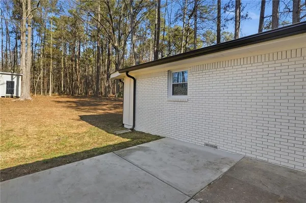a view of a house with backyard and trees