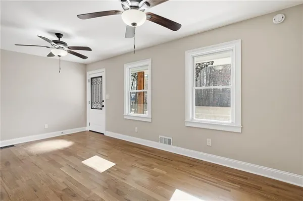 a view of empty room with wooden floor