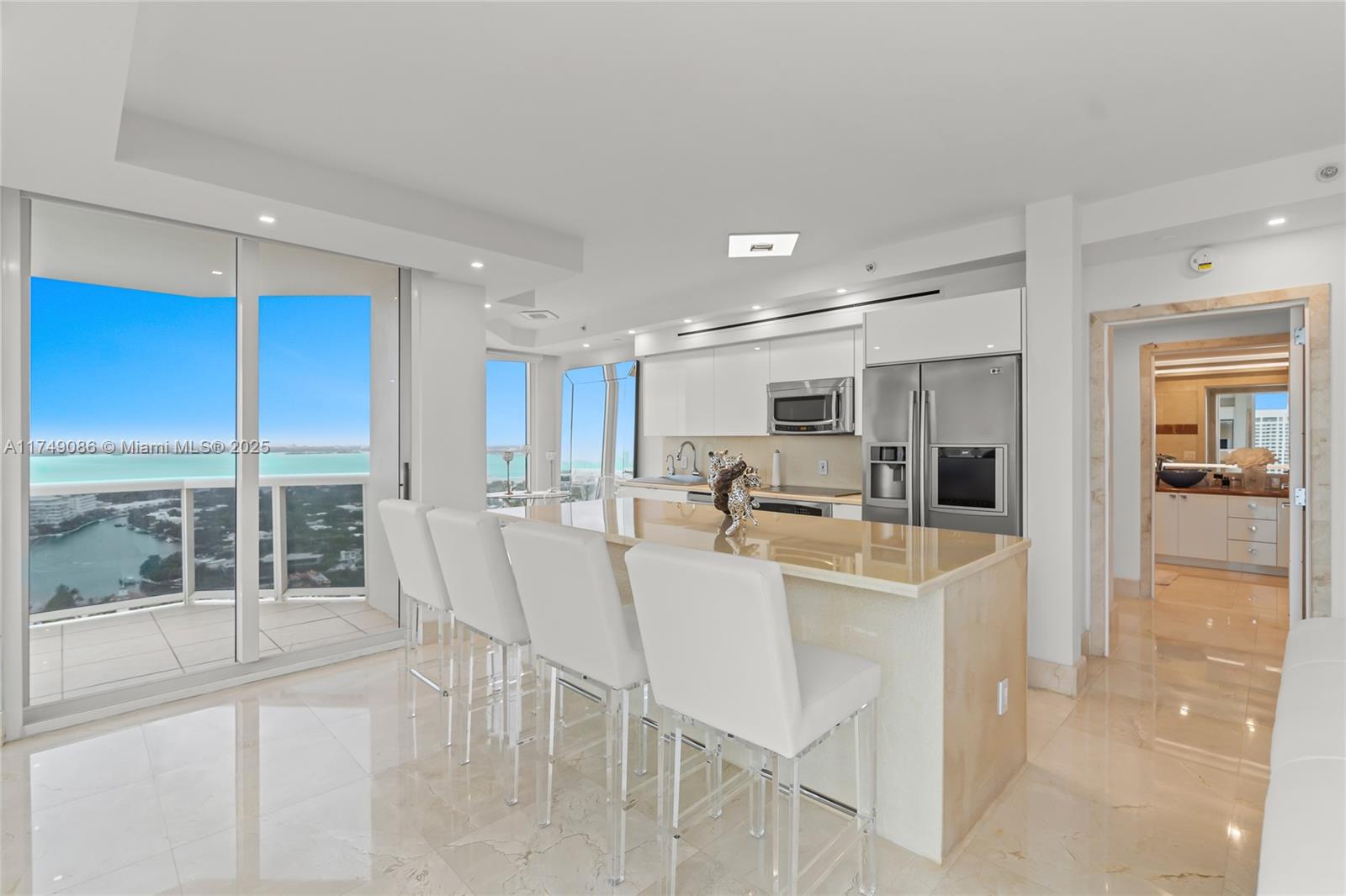 4775 Collins Avenue, Unit 3505 Miami Beach, FL 33140 - Photo 24 of 73 a view of a dining room with furniture large windows and wooden floor