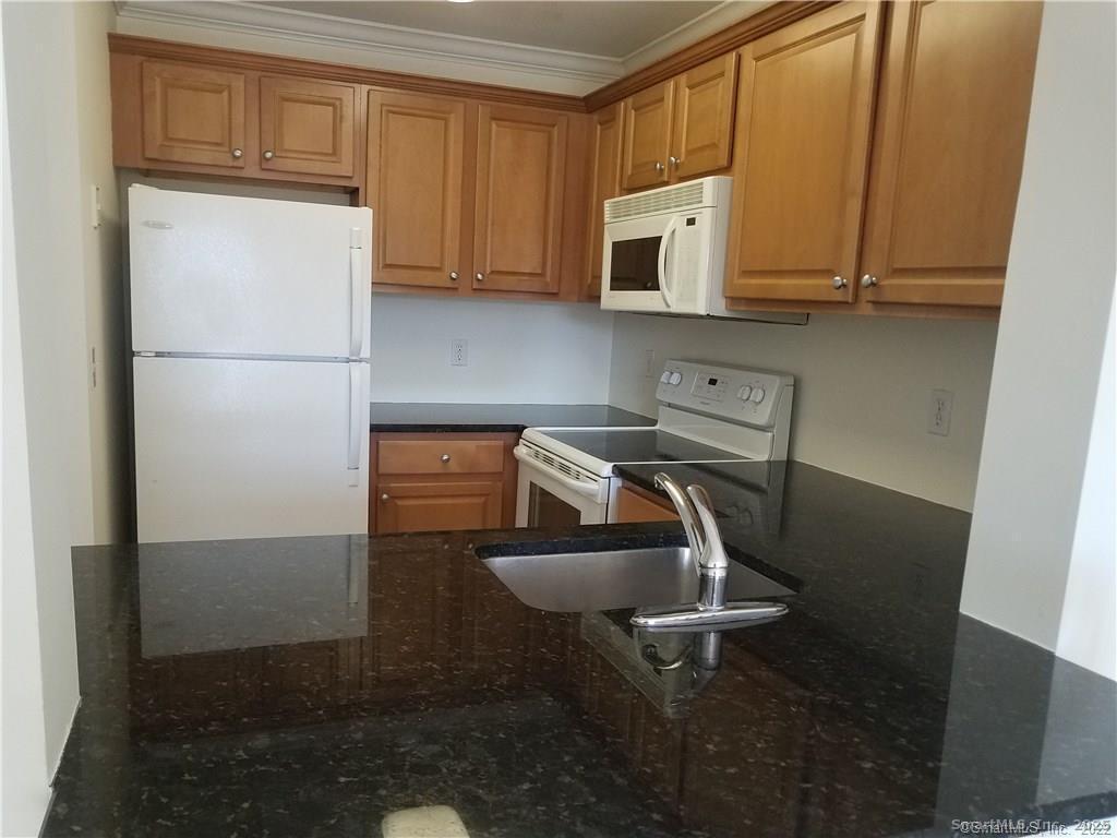 19 Isaacs Street, Unit 406 Norwalk, CT 06850 - Photo 8 of 13 a kitchen with stainless steel appliances granite countertop a refrigerator and a stove top oven