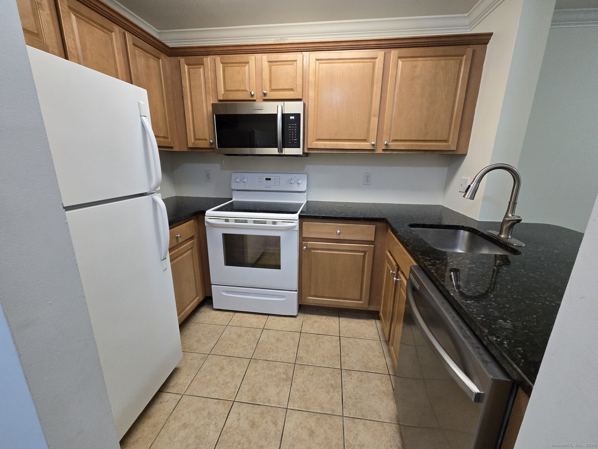 19 Isaacs Street, Unit 406 Norwalk, CT 06850 - Photo 9 of 13 a kitchen with a sink a stove a microwave and refrigerator